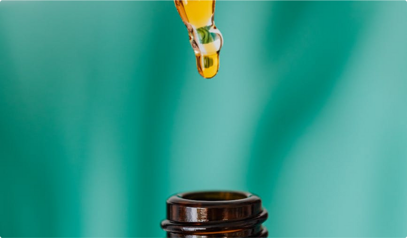 Close up of a pipette dropping liquid into a bottle. 