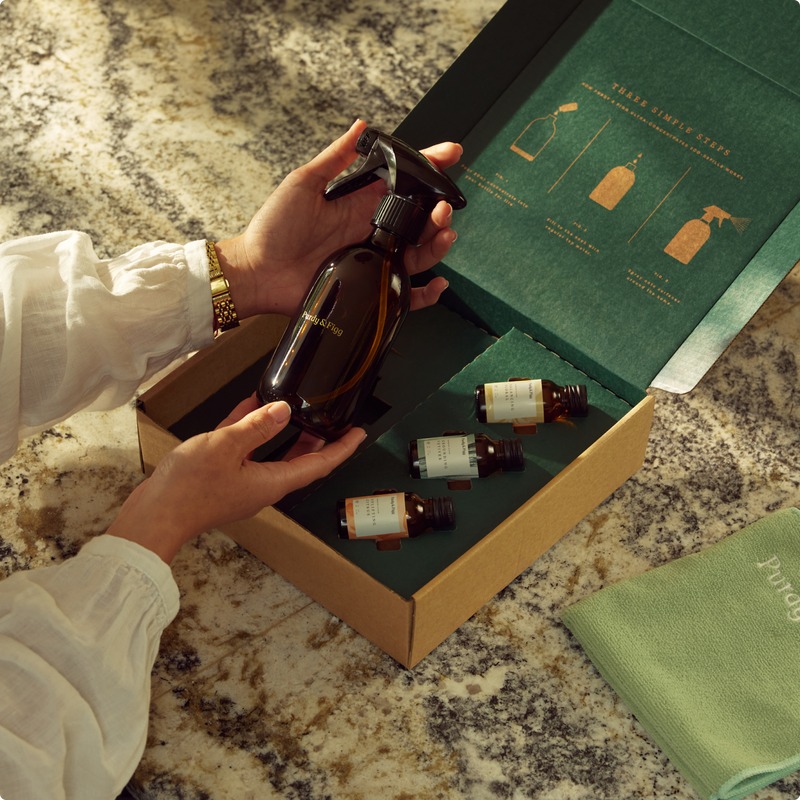 A woman's hands holding a Bottle for Life over an open Starter Kit box on a marble surface